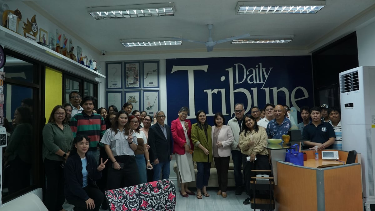 SHE won crowd SM Foundation Inc. executive director for health and medical programs Connie Angeles (center) brought the house down at the Daily Tribune office, as the entire staff left their workstations to take a snapshot with her.