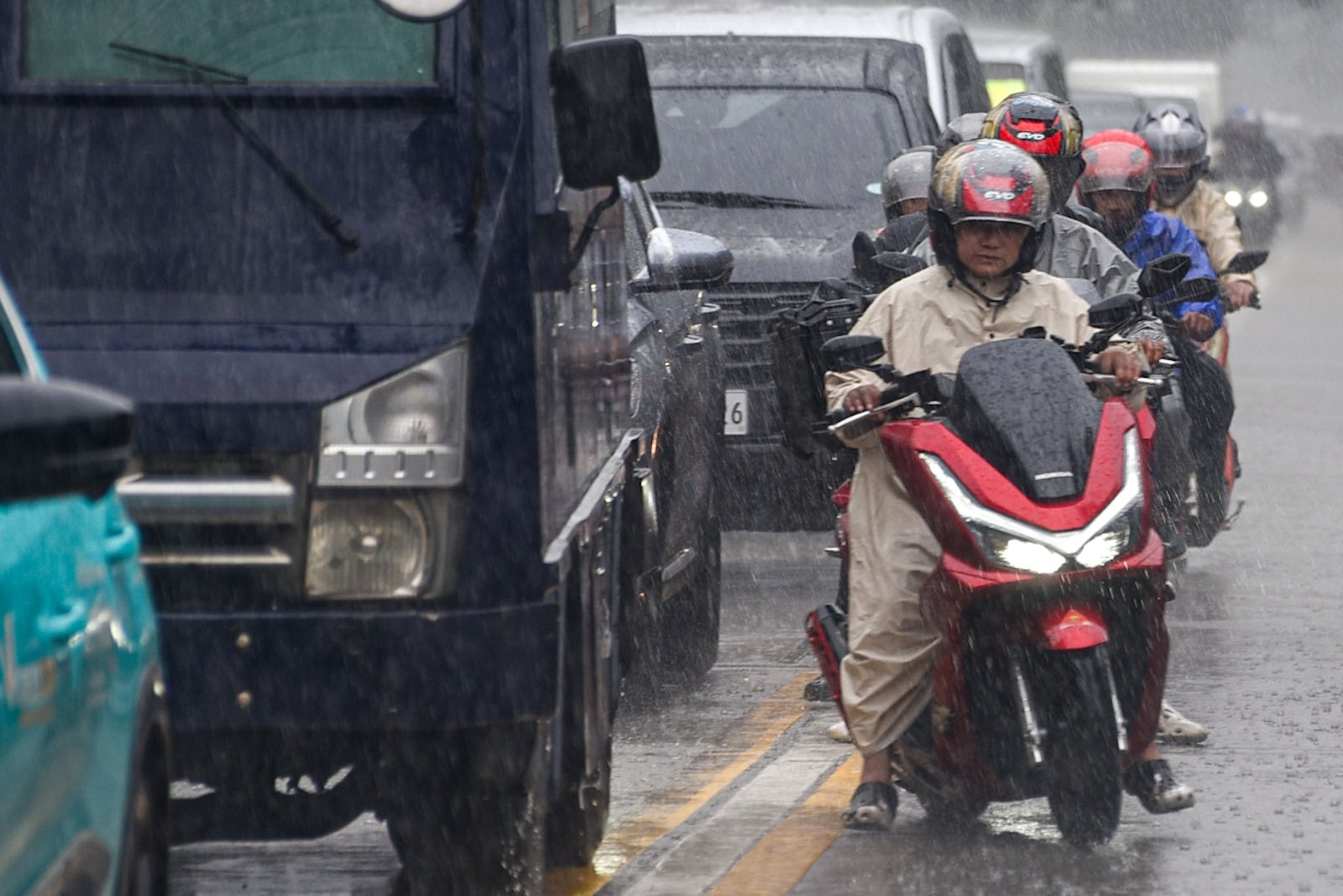 Motorists and pedestrians brave through the heavy downpour brought by a thunderstorm in Manila, on September 15.