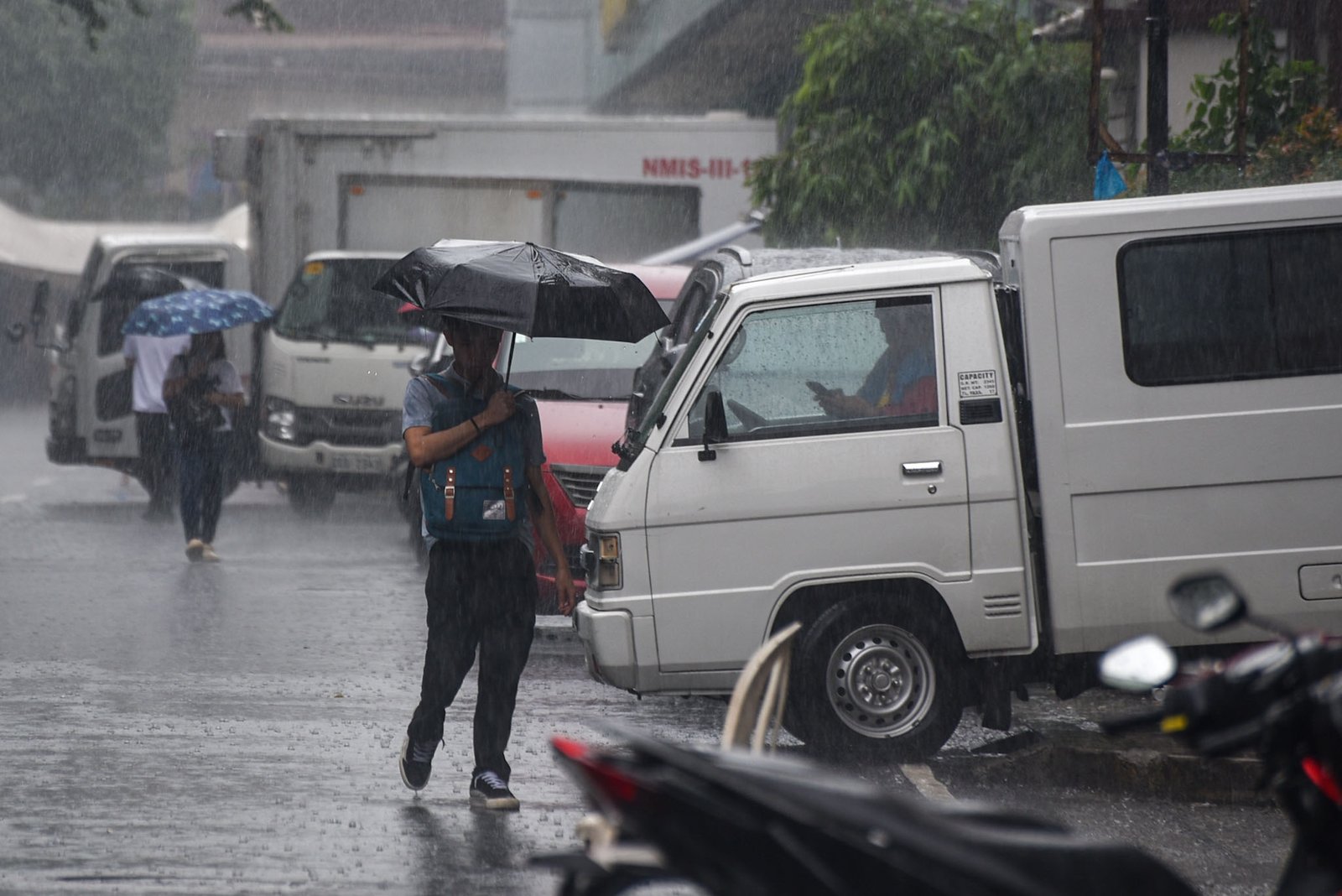 Motorists and pedestrians brave through the heavy downpour brought by a thunderstorm in Manila, on September 15.
