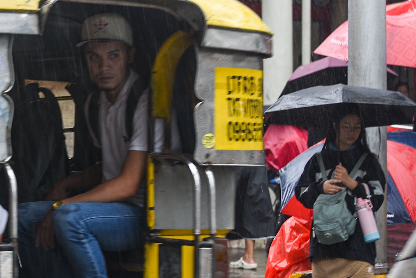 Motorists and pedestrians brave through the heavy downpour brought by a thunderstorm in Manila, on September 15.