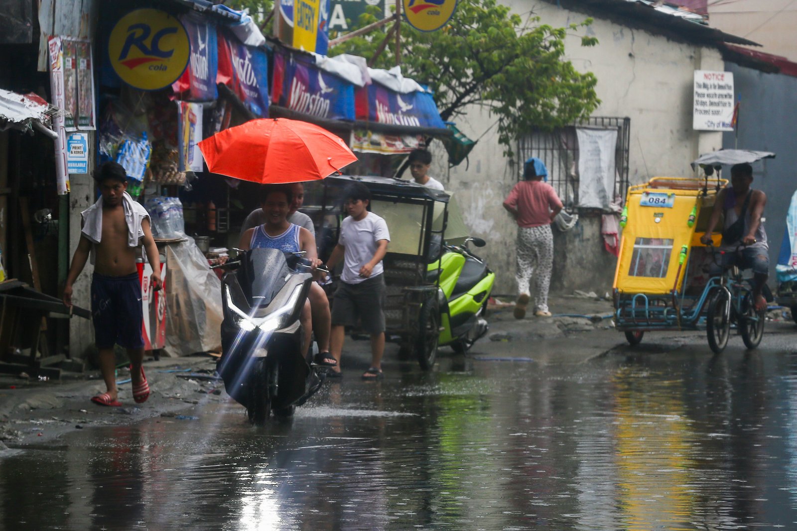 Residents and motorists wade through a flooded street in Baseco, Tondo, Manila, on 17 September 2026, despite health concerns over leptospirosis in the city. The Manila Health Department reported 34 new leptospirosis cases the previous day, bringing the city’s total to 1,354 cases since January, including 41 deaths.