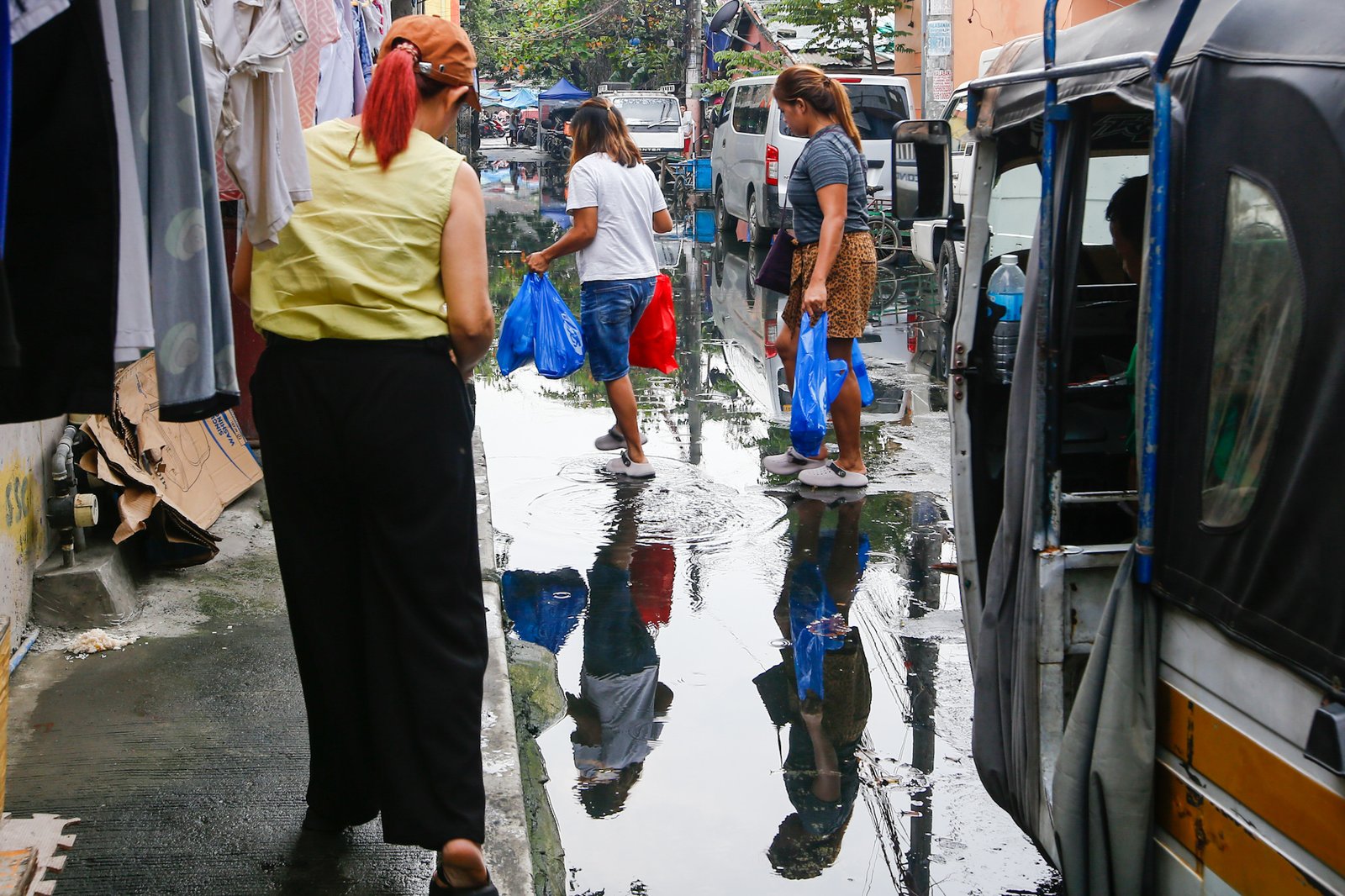 Residents and motorists wade through a flooded street in Baseco, Tondo, Manila, on 17 September 2026, despite health concerns over leptospirosis in the city. The Manila Health Department reported 34 new leptospirosis cases the previous day, bringing the city’s total to 1,354 cases since January, including 41 deaths.