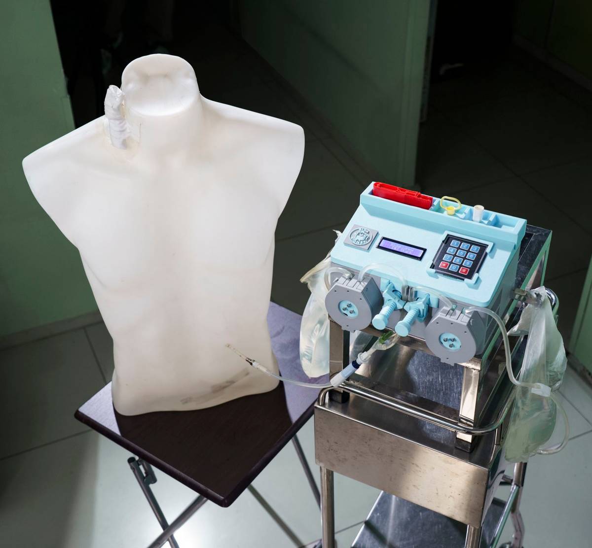 THE BiDaKidney prototype is shown connected to a mannequin, demonstrating its design for managing peritoneal dialysis fluid at home.