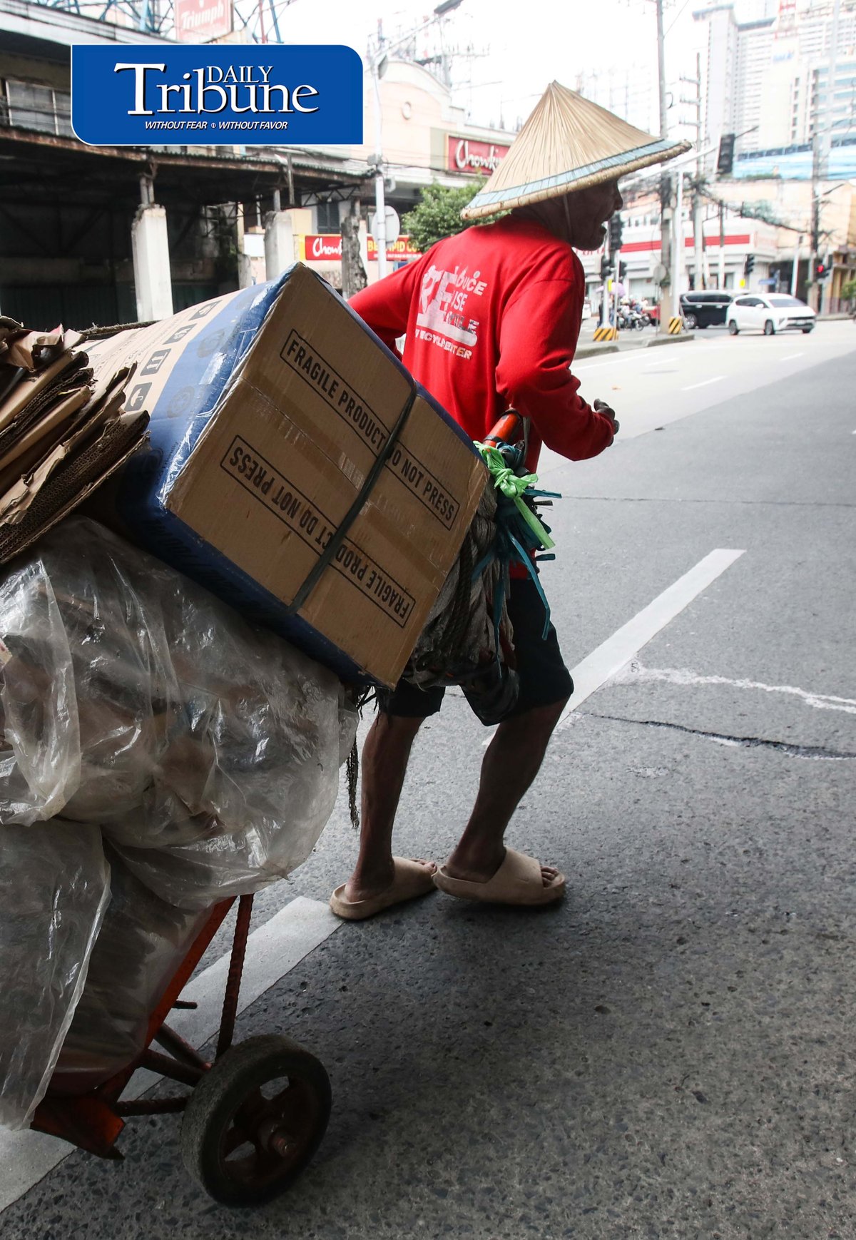 (September 24 2026) A man wearing Salakot, a traditional cone-shape lightweight headgear for protection against the rain, carrying an empty box heading to a junk shop to sell the empty box passing along Edsa in Quezon City. The hat remains a recognized symbol of Filipino identity, resilience, and rural life. Photo/Analy Labor