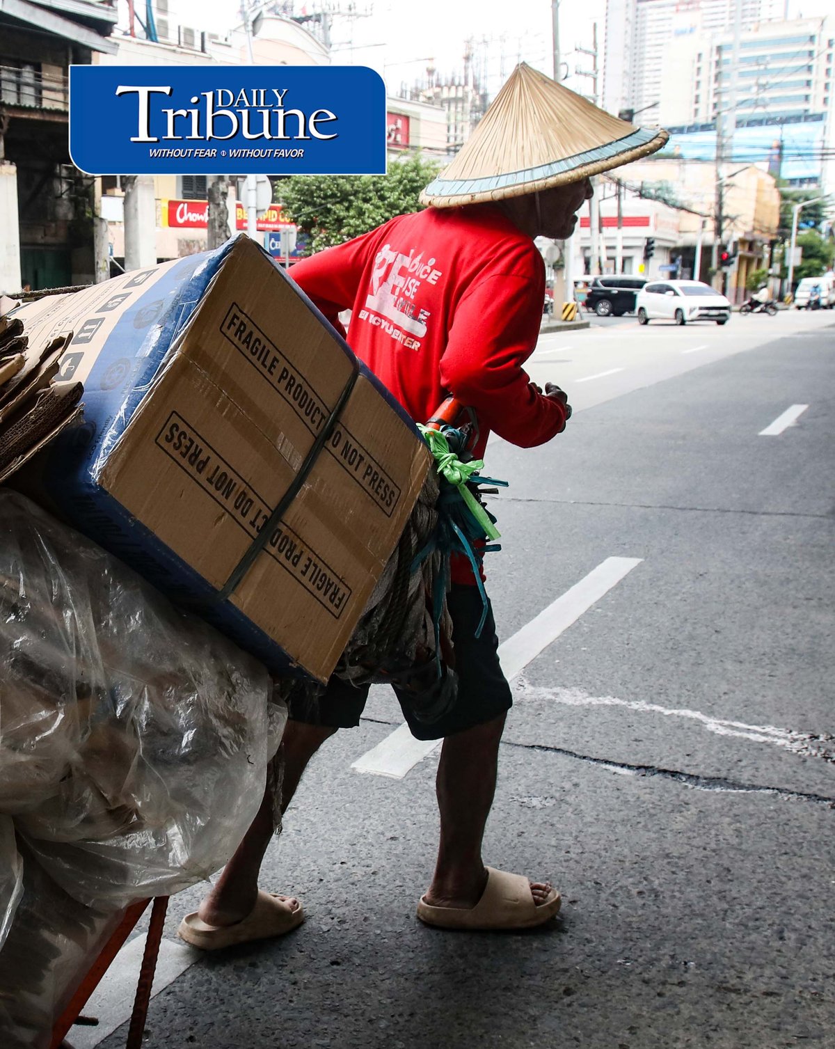 (September 24 2026) A man wearing Salakot, a traditional cone-shape lightweight headgear for protection against the rain, carrying an empty box heading to a junk shop to sell the empty box passing along Edsa in Quezon City. The hat remains a recognized symbol of Filipino identity, resilience, and rural life. Photo/Analy Labor