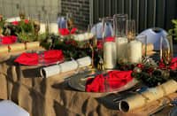 CREATE a warm and inviting Christmas table with a mix of functional pieces and seasonal decorations.