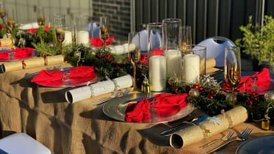 CREATE a warm and inviting Christmas table with a mix of functional pieces and seasonal decorations.