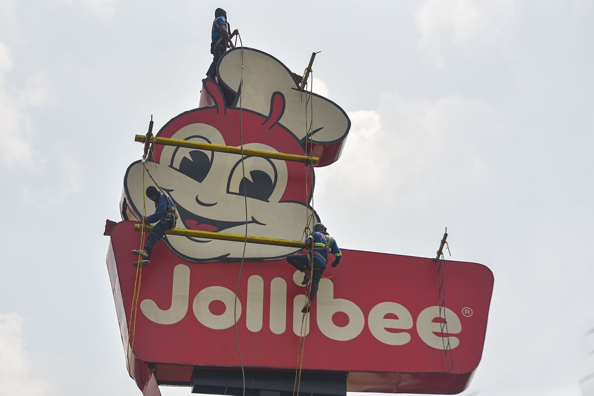 Workers renovating a fast food restaurant's pole sign