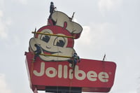 Workers renovating a fast food restaurant's pole sign