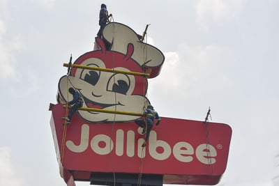 Workers renovating a fast food restaurant's pole sign