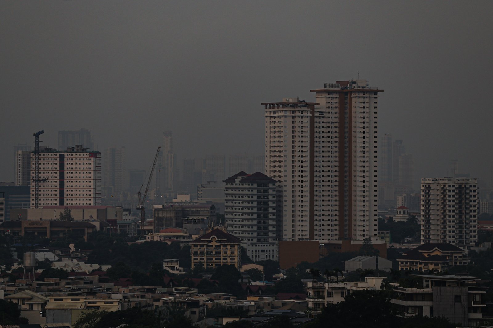 Haze blankets high-rise buildings in Manila, as seen from Quezon City on the morning of 28 September 2026. Air quality in Metro Manila has ranged from moderate to unhealthy levels, with exposure to fine particles potentially aggravating respiratory conditions and causing breathing difficulties. The Department of Environment and Natural Resources–Environmental Management Bureau advises the public to reduce unnecessary outdoor activities, wear a properly fitted N95 or equivalent mask when exposure is unavoidable, keep doors and windows closed when possible, and monitor official air quality advisories.