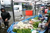 RESIDENTS shop for produce at a temporary floating market in the floodwaters in Bang Kapi district in Bangkok on 28 September 2026.