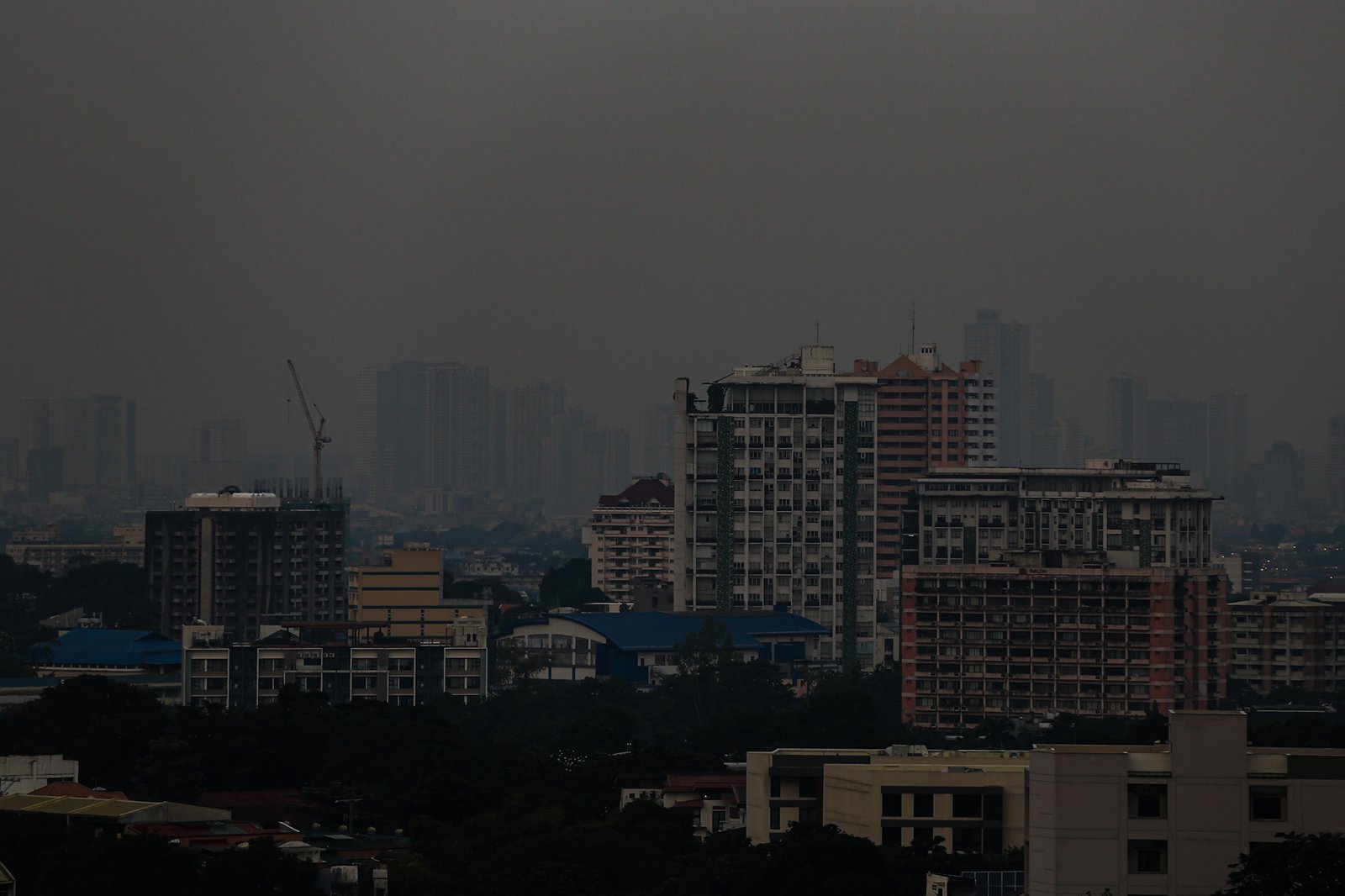 Haze blankets high-rise buildings in Manila, as seen from Quezon City on the morning of 28 September 2026. Air quality in Metro Manila has ranged from moderate to unhealthy levels, with exposure to fine particles potentially aggravating respiratory conditions and causing breathing difficulties. The Department of Environment and Natural Resources–Environmental Management Bureau advises the public to reduce unnecessary outdoor activities, wear a properly fitted N95 or equivalent mask when exposure is unavoidable, keep doors and windows closed when possible, and monitor official air quality advisories.