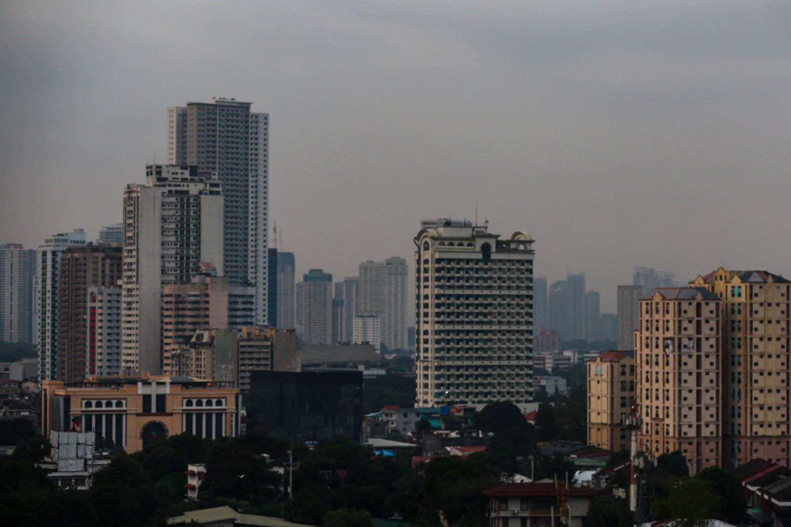 Haze blankets high-rise buildings in Manila, as seen from Quezon City on the morning of 28 September 2026. Air quality in Metro Manila has ranged from moderate to unhealthy levels, with exposure to fine particles potentially aggravating respiratory conditions and causing breathing difficulties. The Department of Environment and Natural Resources–Environmental Management Bureau advises the public to reduce unnecessary outdoor activities, wear a properly fitted N95 or equivalent mask when exposure is unavoidable, keep doors and windows closed when possible, and monitor official air quality advisories.