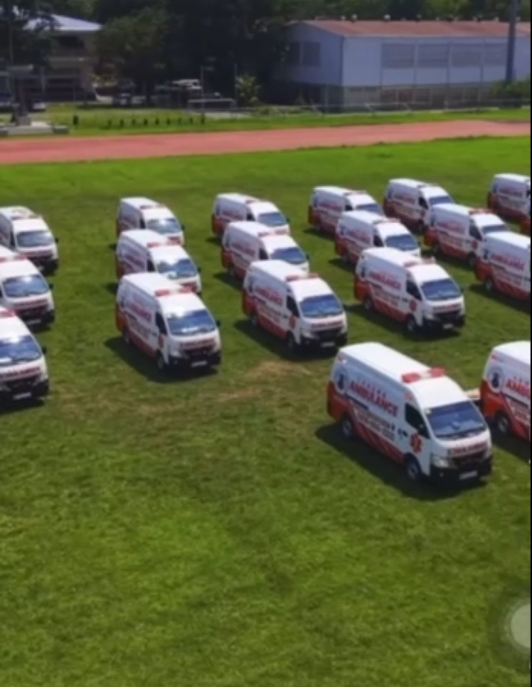 A fleet of white and red ambulances lined up on a field for Laguna’s Ambulance on the Go emergency response program.