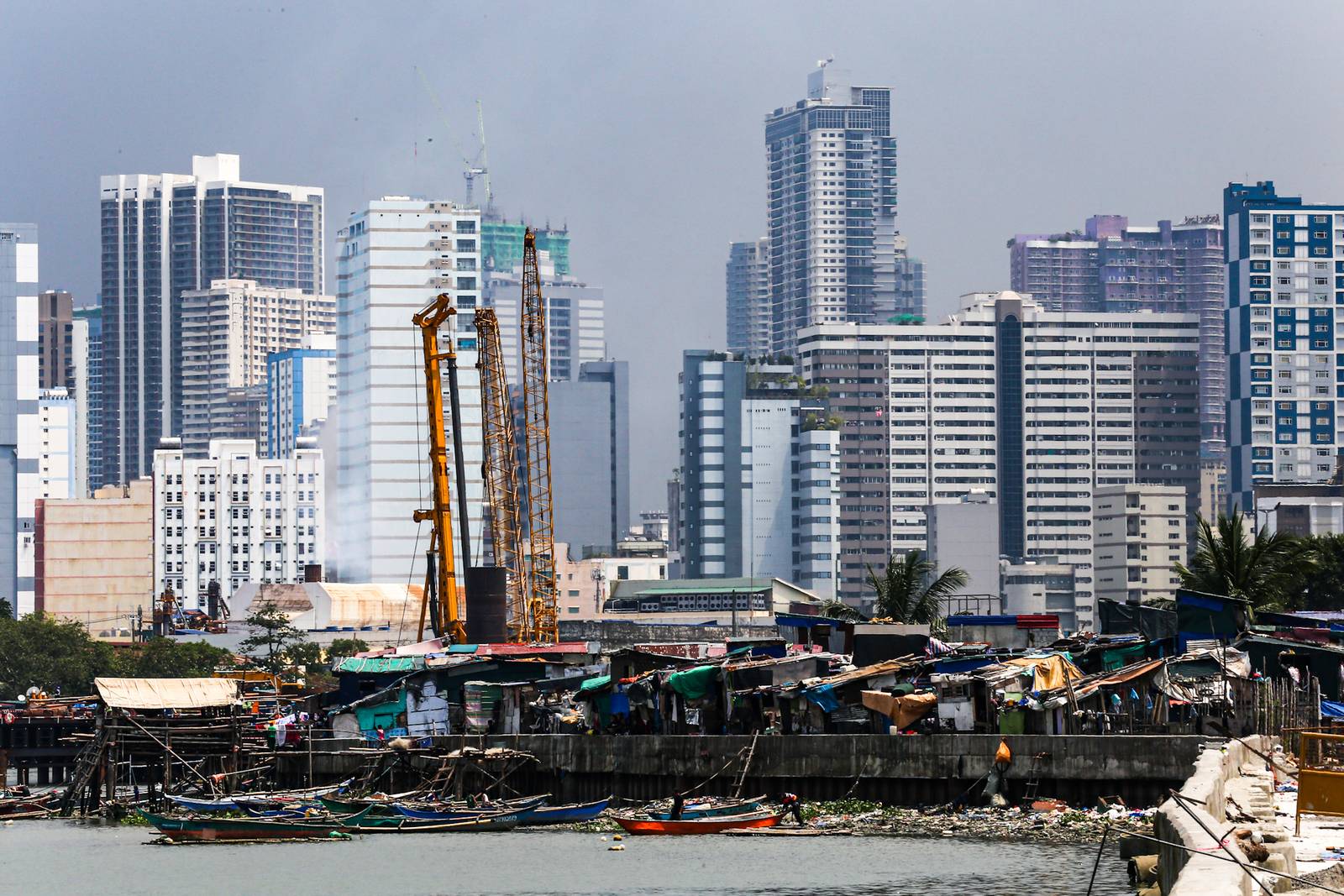 Makeshift homes stand in contrast with high-rise buildings in Manila, in this photo taken on 02 October 2026. The scene comes as the national government’s outstanding debt reached ₱19.39 trillion as of July 2026, according to the Bureau of the Treasury.