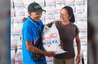 FIRST Lady Liza Araneta-Marcos (right) hands a sack of rice to a driver during an assistance distribution at the Land Transportation Office headquarters in Quezon City on 29 September.