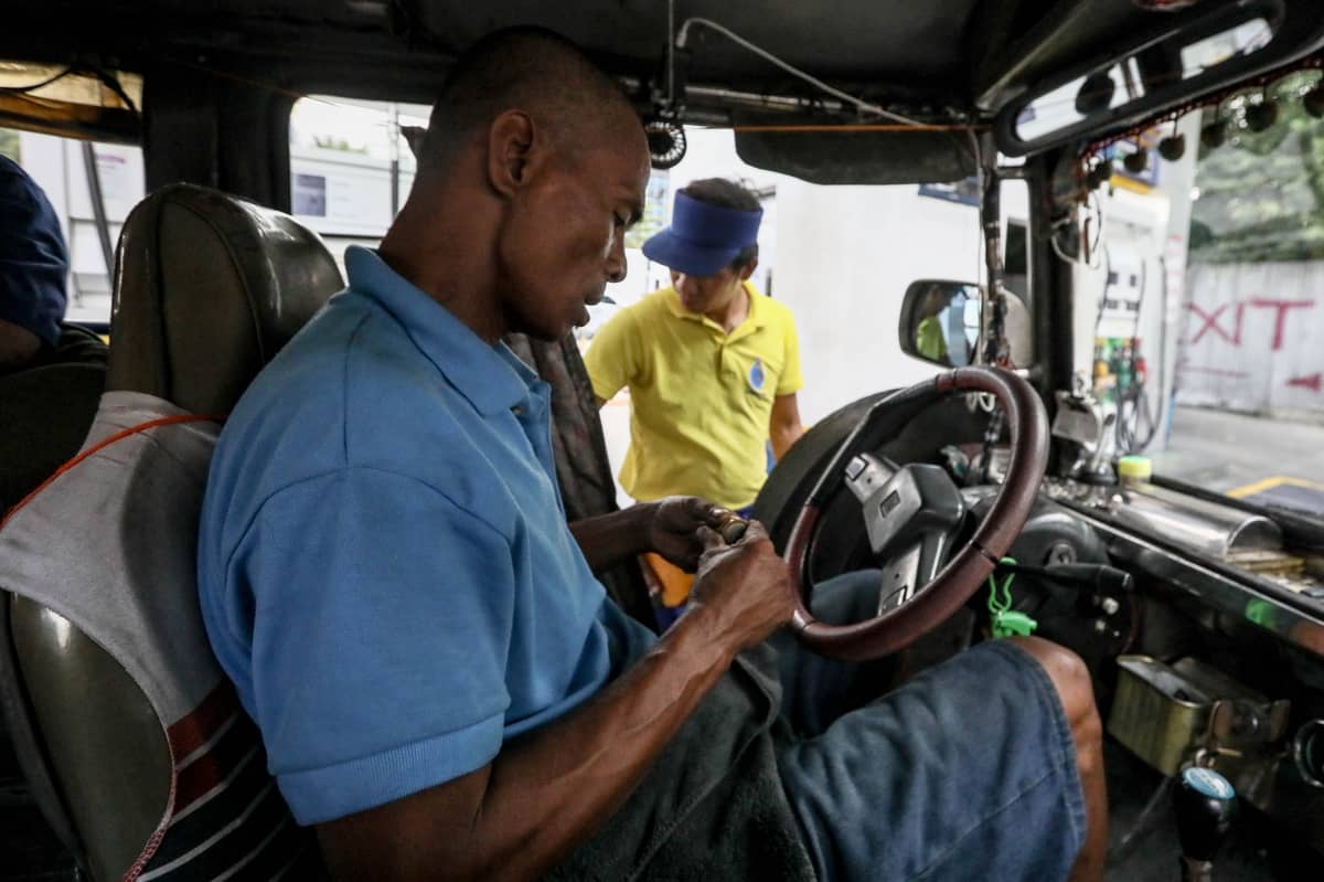 DRIVER of a traditional jeepney counts his fare earnings while refueling at a gas station in Pasay City. Despite a fare increase for the first four kilometers, rising fuel prices continue to squeeze drivers, with pump prices ranging from P81.60 to P104.20 per liter at different stations in Metro Manila.