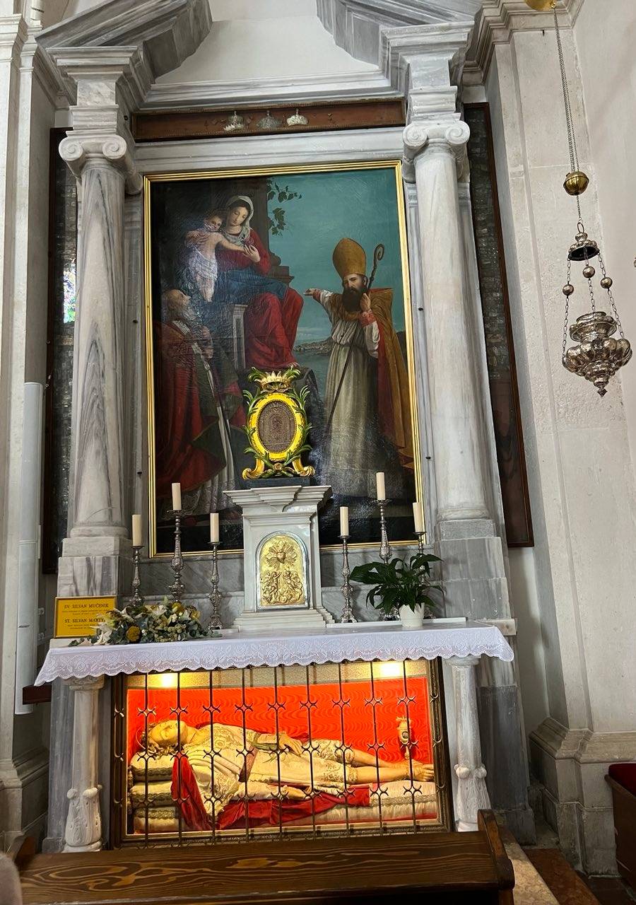 A MADONNA and Child painting with the skeletal remains of Saint Silvan enclosed in a wax sculpture below.
