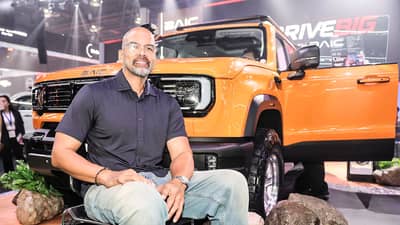 FORMER PBA star Benjie Paras poses with an orange BAIC SUV as the automaker expands its presence in the Philippines.