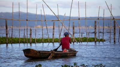 A fisherman casts his net in Laguna de Bay off Paete, Laguna, as the lake’s water level drops to 12.41 meters amid concerns over prolonged dry conditions.
