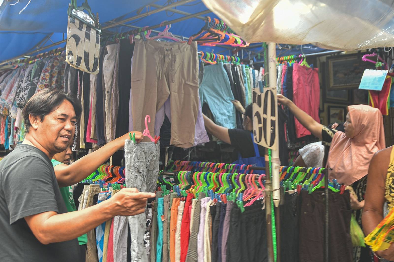 Thrifted clothes are displayed for sale along the streets of Quiapo, Manila, as vendors offer secondhand garments at affordable prices on October 10.

Filipinos turn to ukay-ukay shops and street stalls to find quality clothing at lower prices. l Zedrich Xylak Madrid
