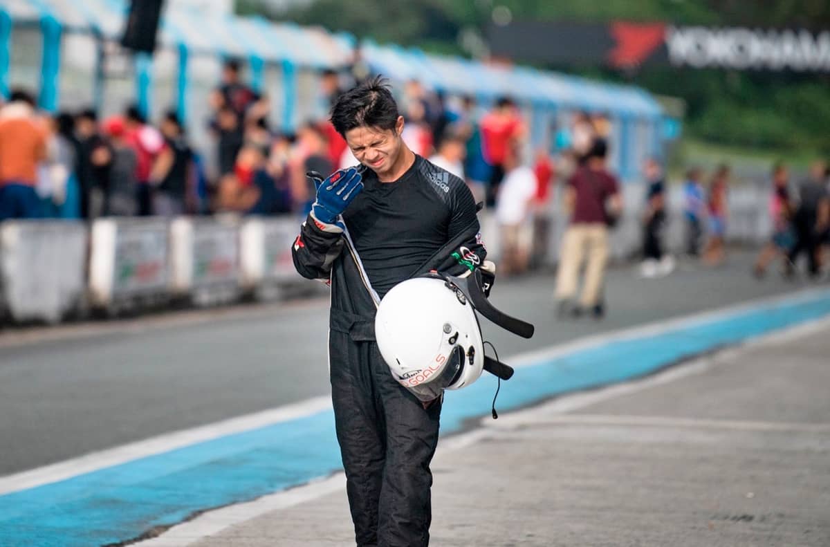 HELMET in hand, Raffy Rabe walks along the pit lane in his racing suit.