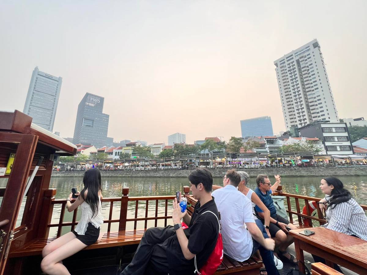 EUROPEAN and Asian tourists enjoy Singapore’s business district during a boat ride at Marina Bay.