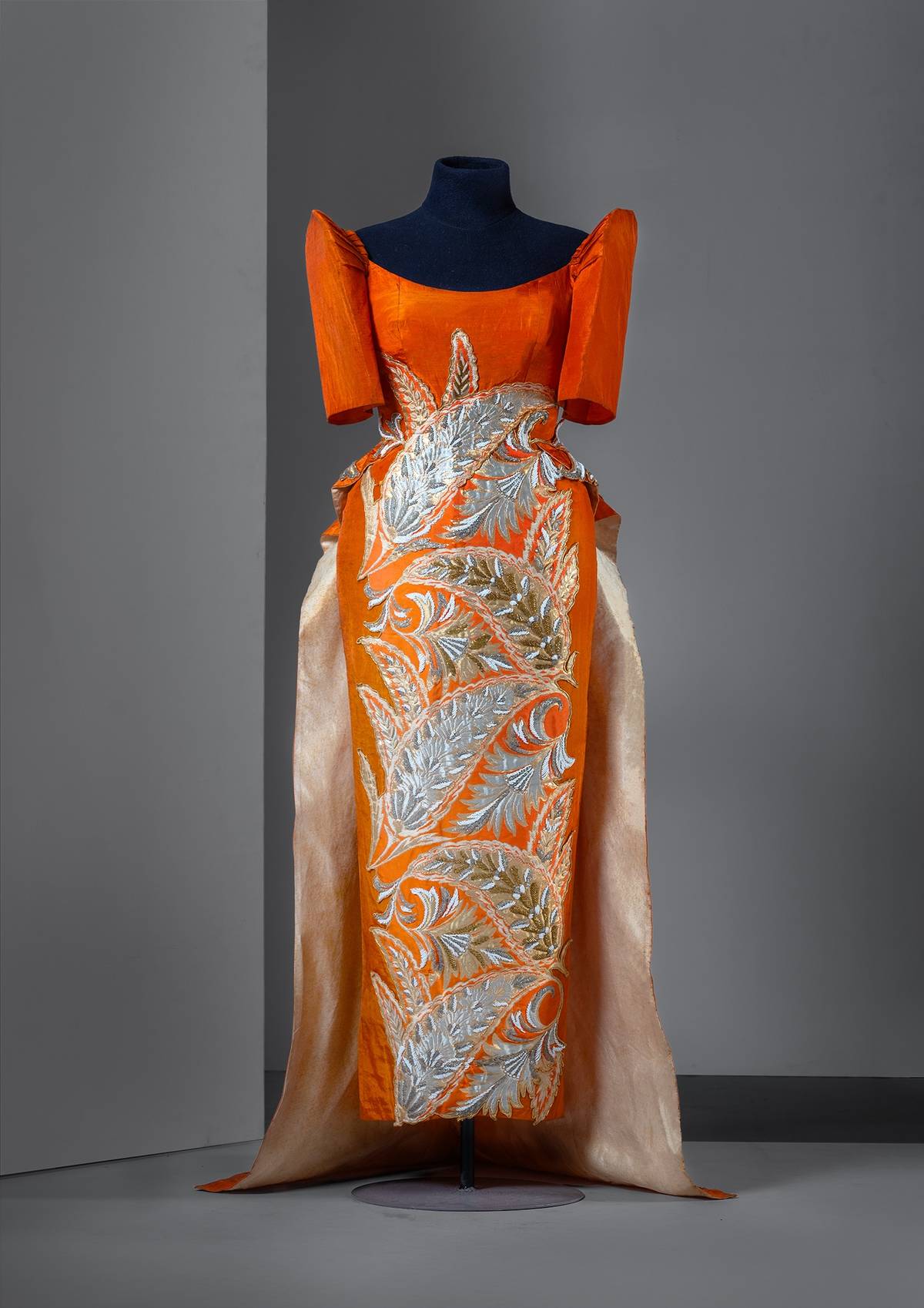Ramon Valera (1912-1972)
Orange satin terno with a peplum train and silver and gold beaded floral appliqués, c. 1965-1966. Worn by former First Lady Leonila ‘Inday’ Garcia. A gift of Carlos Garcia Campos.