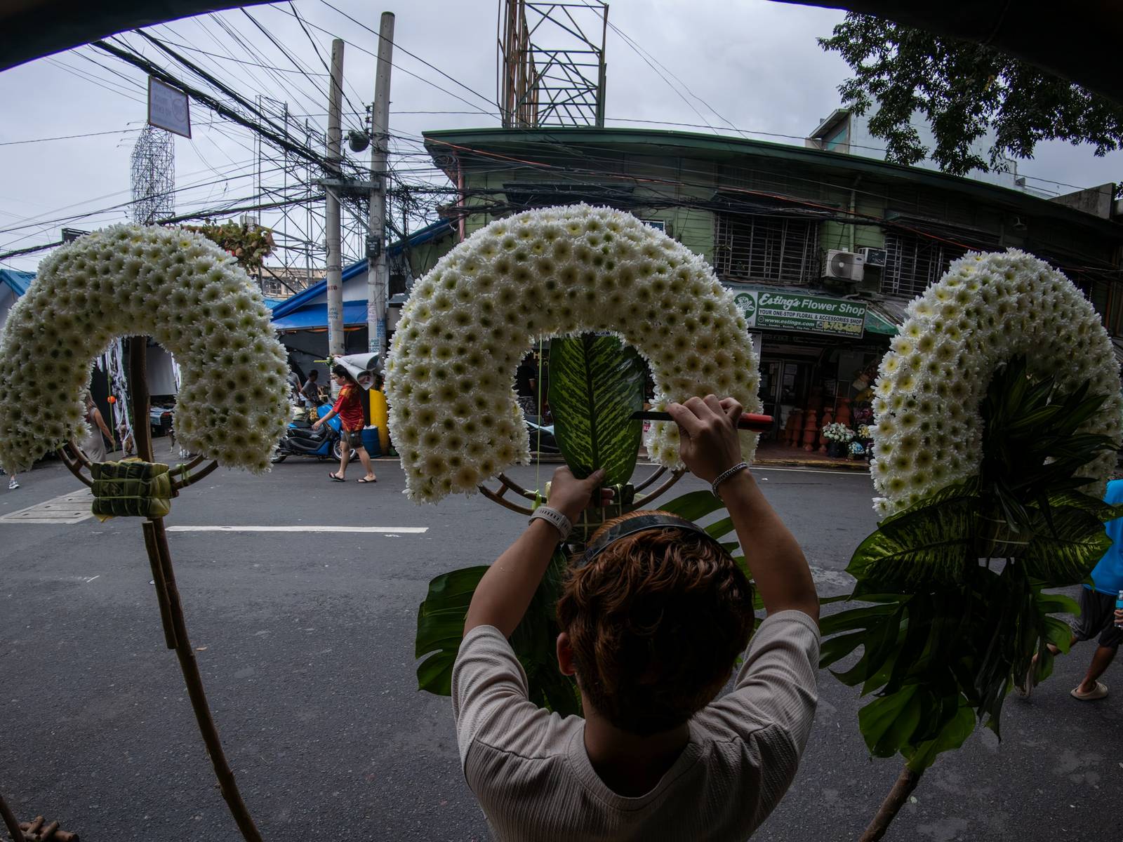 Florists arrange flowers for the dead at Dangwa Flower Market in Manila on 12 October 2026, ahead of the observance of All Saints’ Day and All Souls’ Day, collectively known as Undas. Prices of flower arrangements range from ₱100 to ₱5,000.