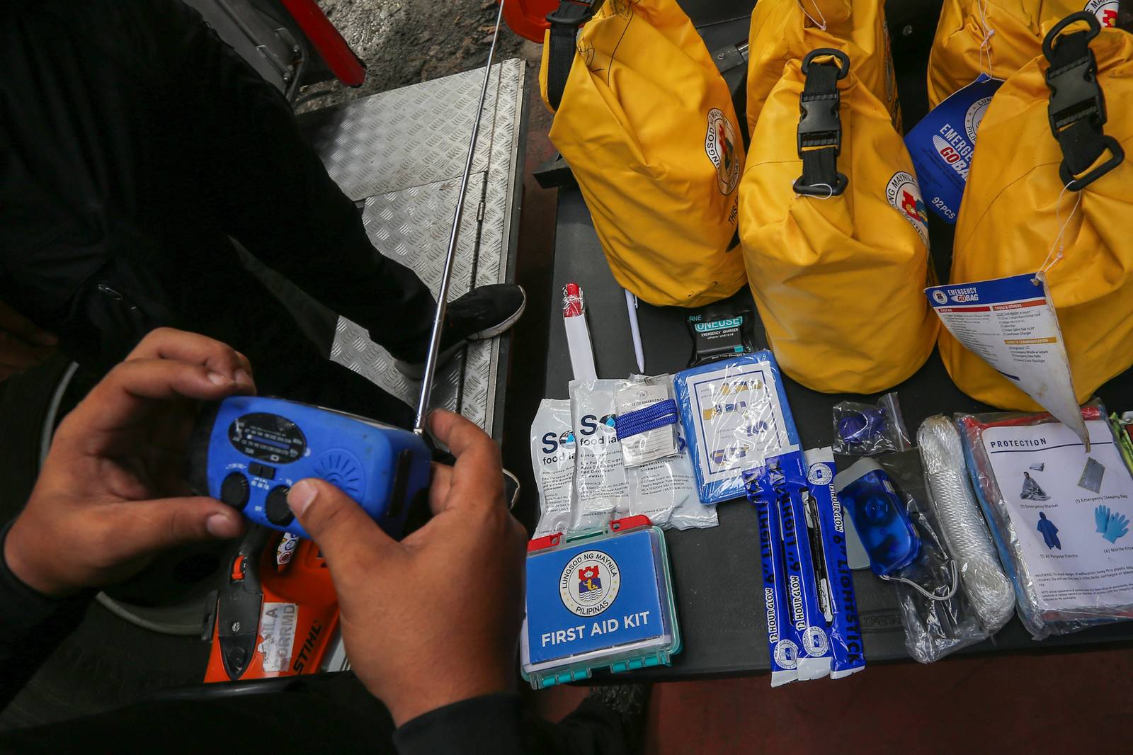Personnel of the Manila Disaster Risk Reduction and Management Office (MDRRMO) display the contents of a go bag at their headquarters in Manila on 13 October 2026, in observance of the International Day for Disaster Risk Reduction. The annual observance highlights the importance of disaster preparedness, emphasizing that resilience starts at home through proper planning and emergency supplies.
