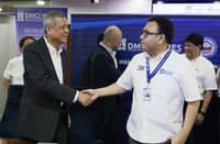 DMCI Homes president Alfredo Austria (left) and Department of Human Settlements and Urban Development Secretary Jose Ramon Aliling shake hands.