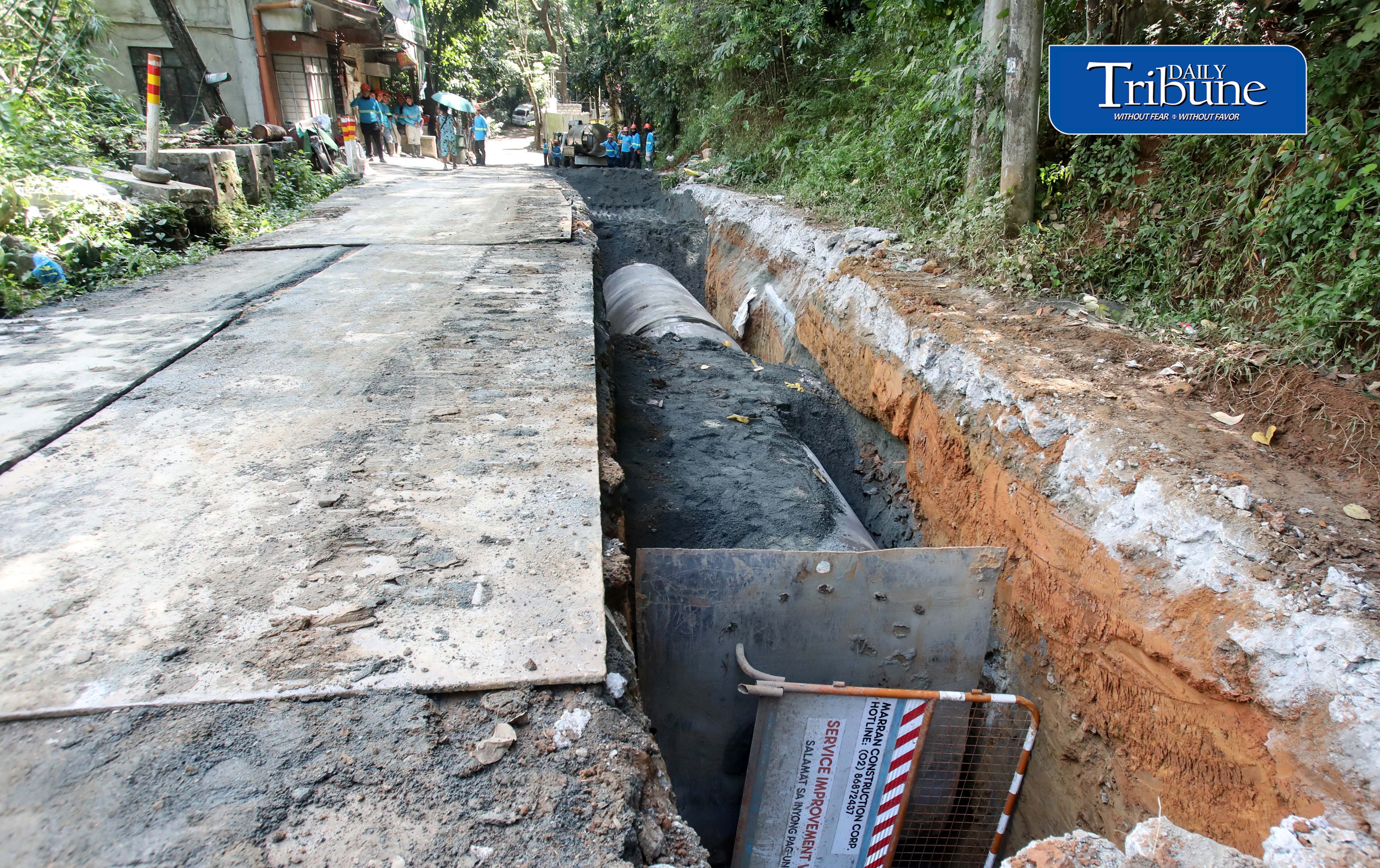 Workers install water pipes