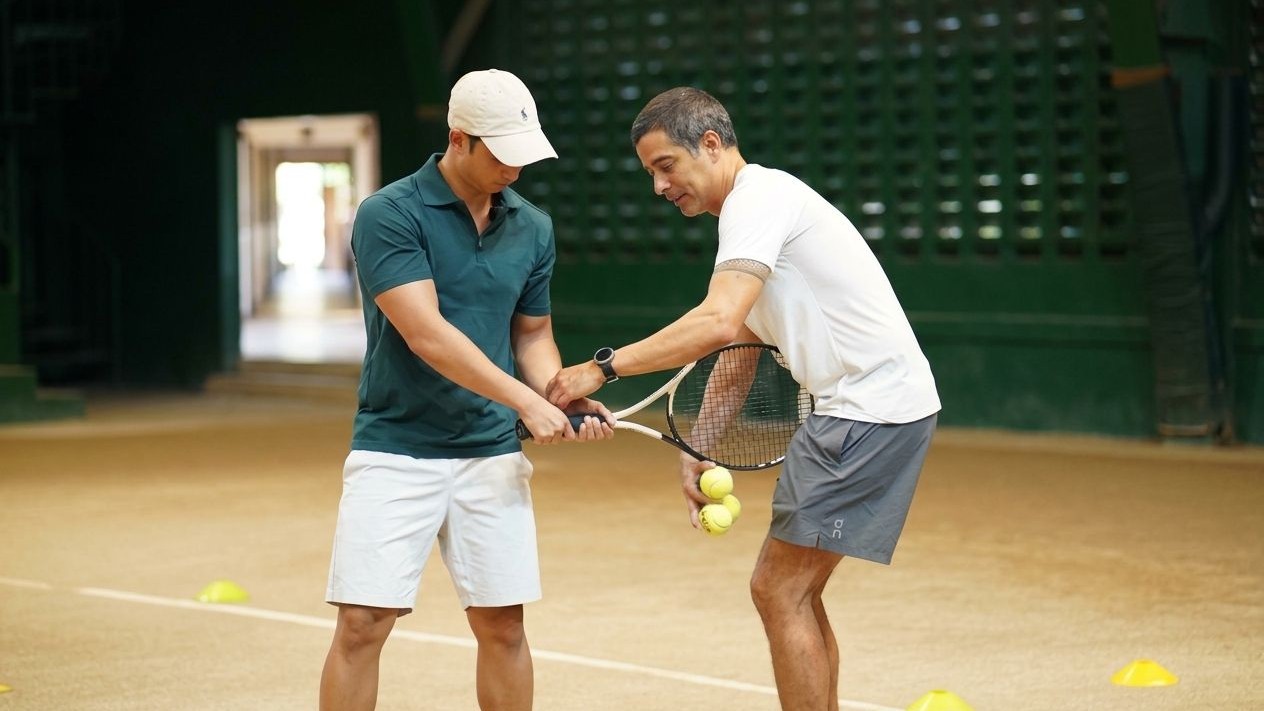 ROLAND Kraut, PCA Open Committee Member and DLSU Tennis Head Coach (right) teaches a member of the press the basics of tennis at a mini-clinic held following the media launch of the 43rd PCA Open, the first iteration the Palawan Group of Companies has served as a major backer.