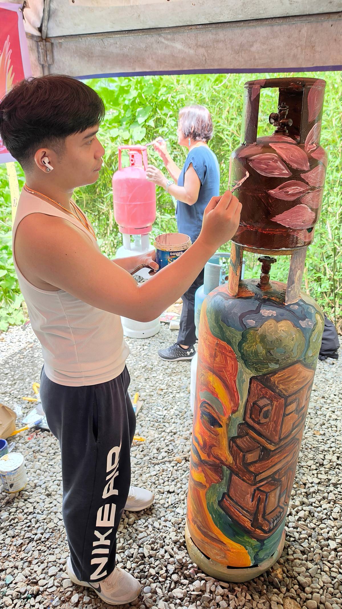 AN artist participant painting on an LPG gas tank.