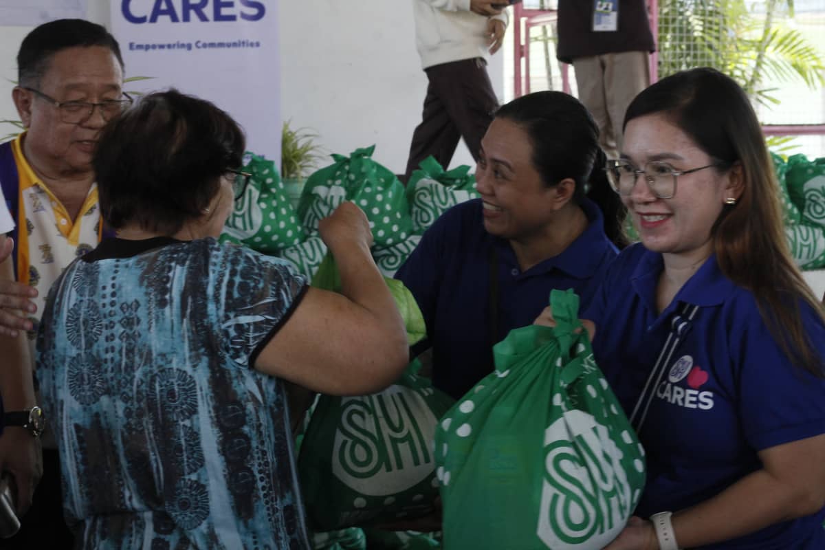 IRENE Agbayani (right) of SM Center Dagupan, assists in distributing relief care packages to local residents during the community outreach project. To her, a handover of a relief pack means a chance to lift a resident’s spirits, even just for that moment.