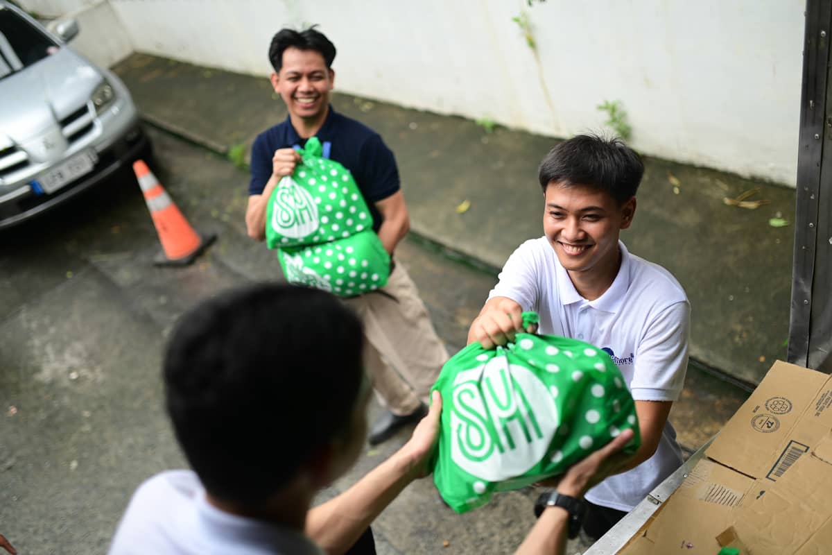 VOLUNTEERS assist in loading SM Kalinga Packs onto trucks for distribution to affected communities.