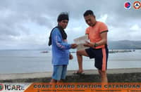 Coast Guard personnel talk to Catanduanes fisherfolk to warn them against venturing out to sea due to Super Typhoon "Rosal" (CHAMPI).