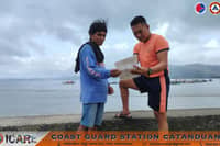 Coast Guard personnel talk to Catanduanes fisherfolk to warn them against venturing out to sea due to Super Typhoon "Rosal" (CHAMPI).