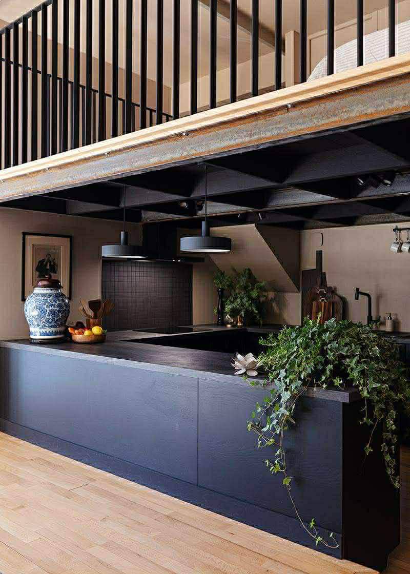 THE sunken kitchen below the mezzanine guest room with exposed metal beams