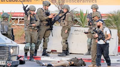 ISRAEL army soldiers gather by the bodies of two armed Palestinian men after a fire exchange at the northern checkpoint of Hebron in the Israeli-occupied West Bank on 23 October 2026.