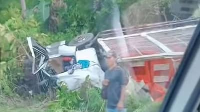 A truck carrying plastic crates lies overturned beside Gumaca Bypass Road in Barangay Villa Arcaya, Gumaca, Quezon, after a crash that killed its driver and a helper and injured another helper.