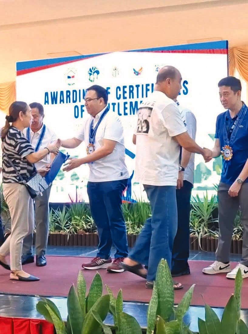 SECRETARY Aliling, along with Senior Undersecretary Eduardo Robles Jr. and Cebu City Mayor Nestor Archival, awards a Certificate of Entitlement (COE) to Cebu beneficiaries, advancing efforts to secure land tenure for Filipino families.