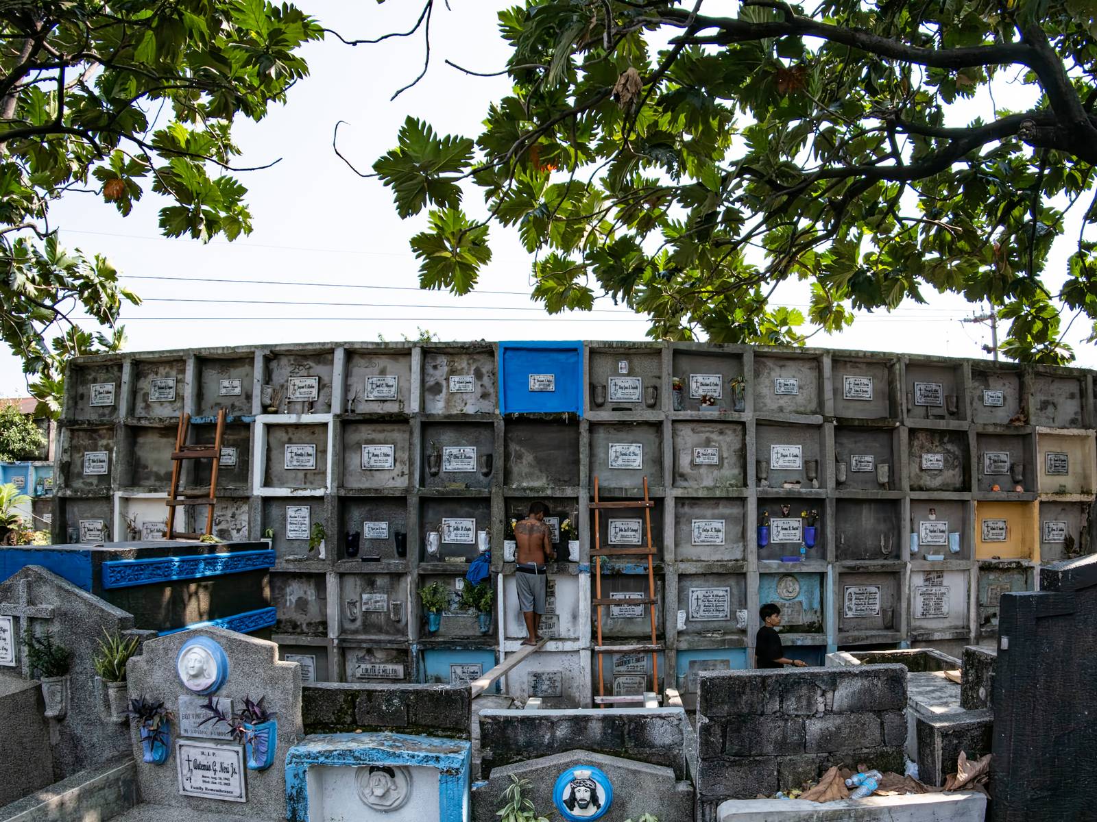 Caretakers and visitors clean and repair graves at the Pasay City Public Cemetery on 25 October 2026, ahead of the October 28 deadline for cemetery preparations for Undas.