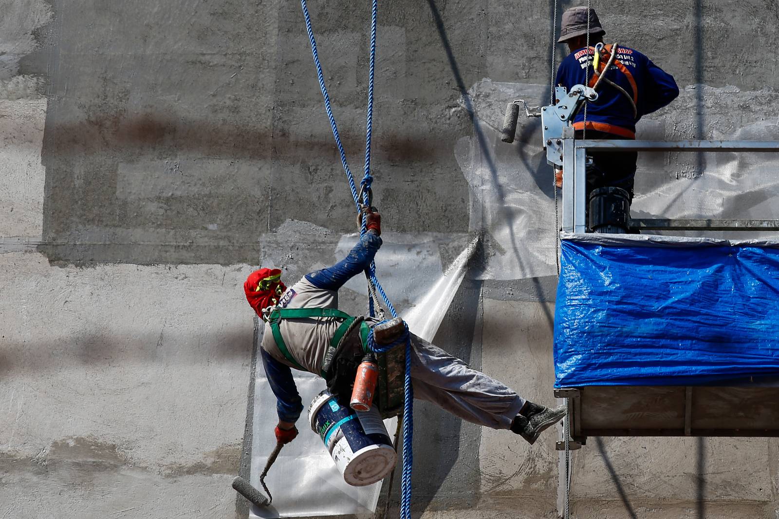 High-rise workers apply waterproofing to a building in Manila on 26 October 2026, as the Department of Labor and Employment clarifies compensation coverage for heat-related illnesses under the Employees’ Compensation Program amid the “super” El Niño and extreme heat.