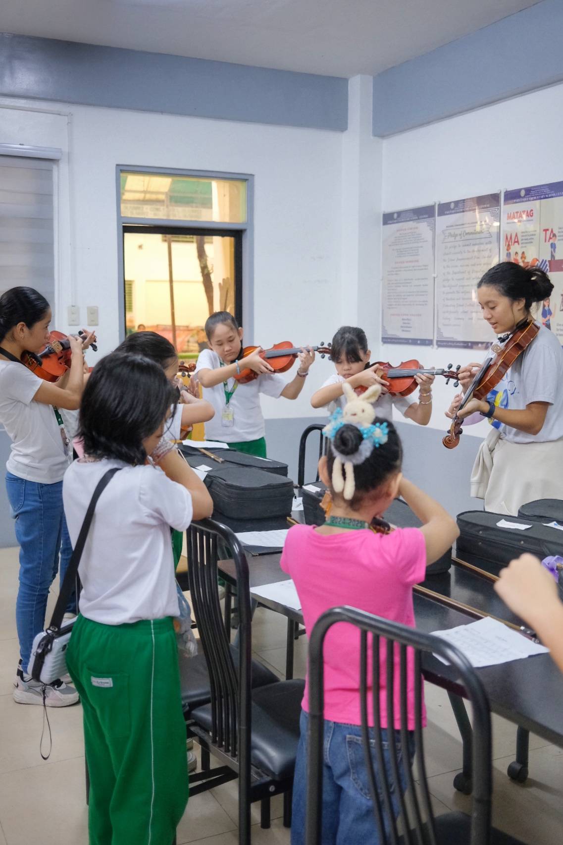 YOUNG learners practice their violin skills with guidance from an ARTvocacy volunteer.