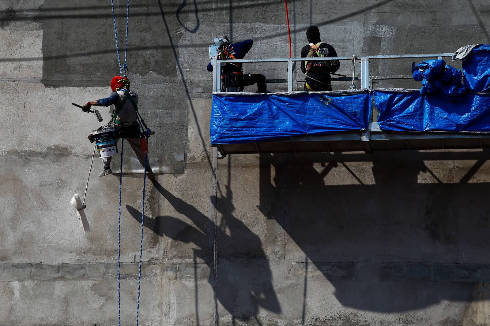 High-rise workers apply waterproofing to a building in Manila on 26 October 2026, as the Department of Labor and Employment clarifies compensation coverage for heat-related illnesses under the Employees’ Compensation Program amid the “super” El Niño and extreme heat.