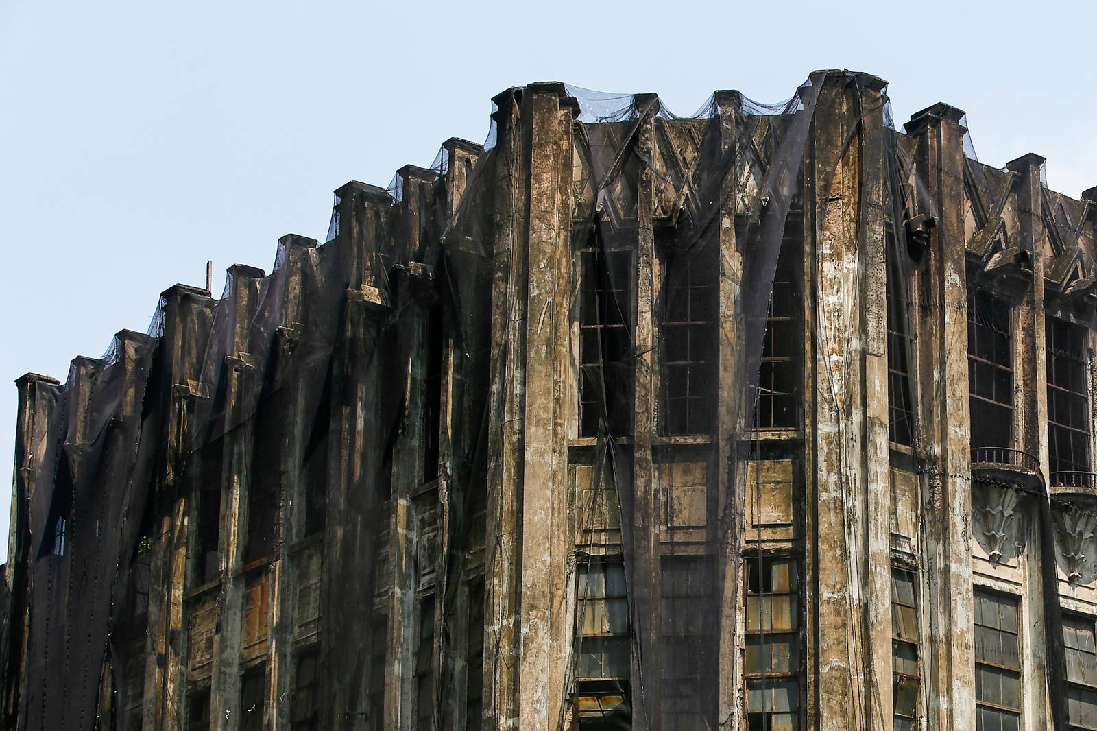 Protective nets cover the pre-war Art Deco IDES O’Racca Building in Divisoria, Manila, to shield vendors, shoppers and pedestrians from falling debris in this photo taken on 26 October 2026. Declared a cultural property by the National Museum of the Philippines, the building reportedly faces demolition despite calls for its preservation by heritage groups.