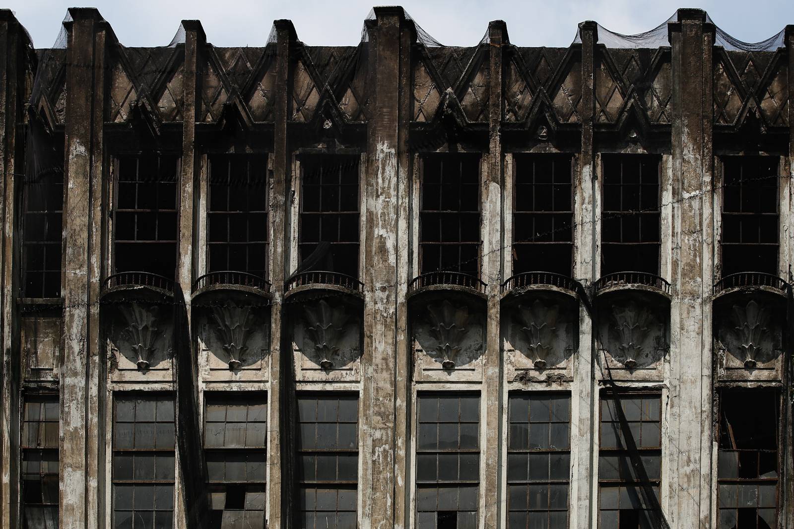 Protective nets cover the pre-war Art Deco IDES O’Racca Building in Divisoria, Manila, to shield vendors, shoppers and pedestrians from falling debris in this photo taken on 26 October 2026. Declared a cultural property by the National Museum of the Philippines, the building reportedly faces demolition despite calls for its preservation by heritage groups.