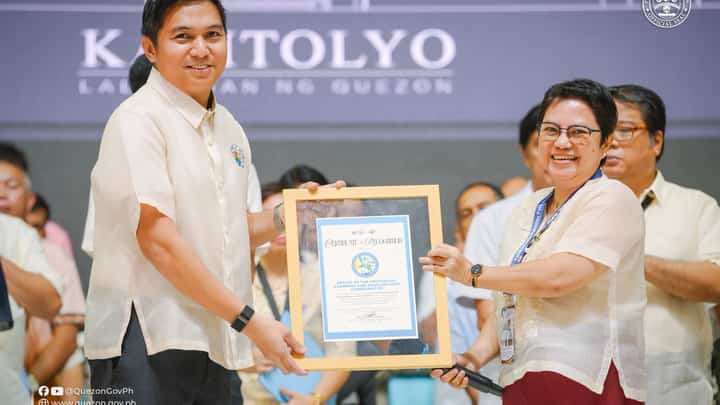 A Quezon provincial official receives a certificate of recognition for the Office of the Provincial Planning and Development Coordinator during the regular flag-raising ceremony on Monday, 26 October. The recognition acknowledges the province's approved and ratified Provincial Development and Physical Framework Plan 2021–2030.